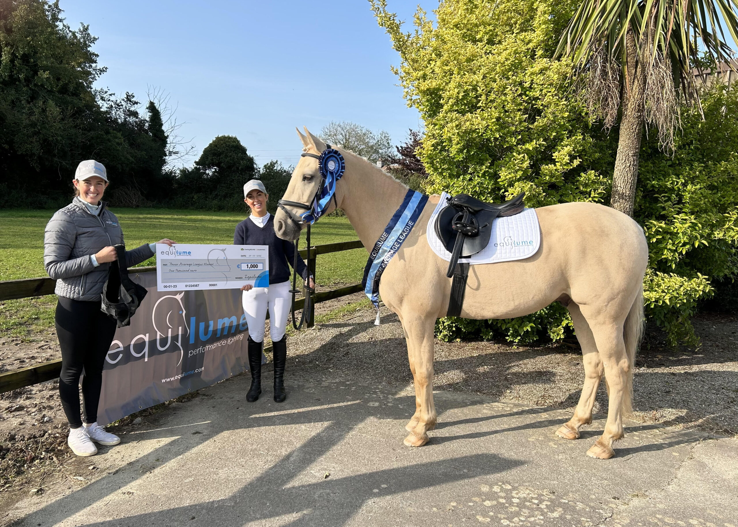 Alyssa O'Neill from Equiratings presents the winner of the Power Average League, Rolline O'Callaghan, with a presentation cheque and Equilume Cashel Light Mask. Rolline holds her palomino horse Splendid B.